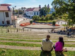 Students sitting on top steps of outdoor amphitheater